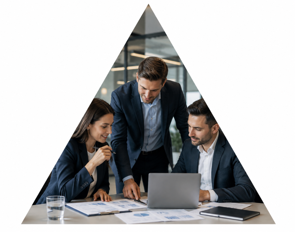 Equipo de profesionales reunido en una oficina revisando documentación y trabajando con un portátil.